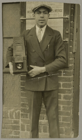 Portrait of Paul Henderson with camera — circa 1920
