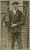 Portrait of photographer Paul Henderson as a young man, posing with his large format camera. Henderson moved to Baltimore, Maryland, in 1929 and became a photojournalist for the Afro-American newspaper. The newspaper called him their “first photographer.” In addition to his job at the Afro-American, Henderson worked as a freelance photographer.
