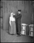 Doctor conducting an eye examination on a woman at Pier 9 in the Locust Point area of Baltimore, Maryland. The woman was among others who came in to Baltimore via the North German Lloyd steamship the SS Neckar. The doctor is looking for trachoma, an infectious disease of the eye.