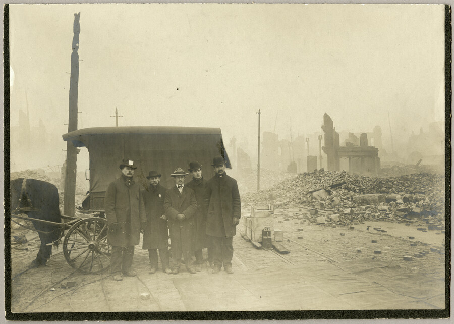 A demolition crew in Baltimore posing beside a dynamite apparatus as part of cleanup procedures in the aftermath of the Great Baltimore Fire of 1904.