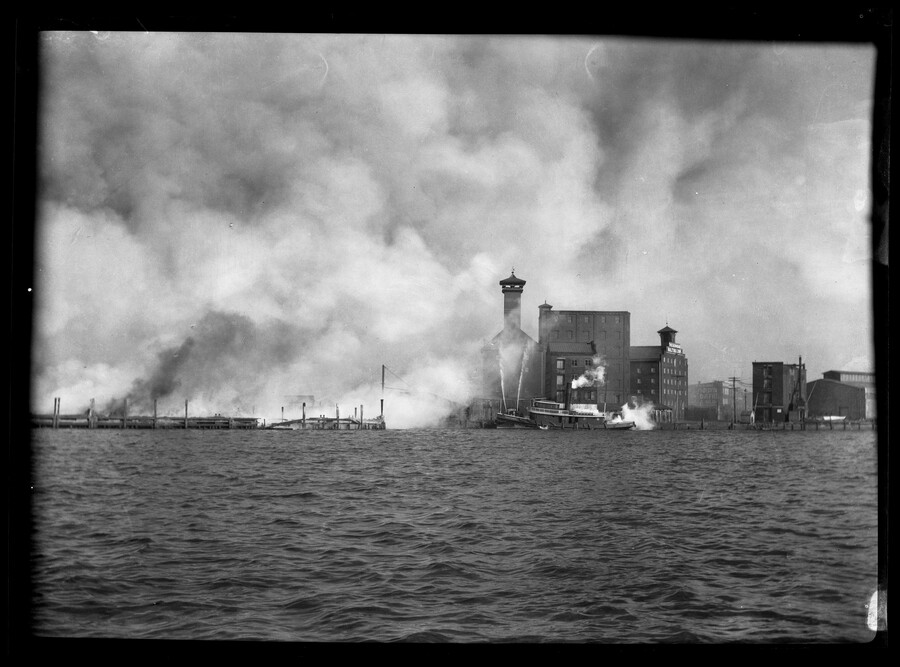 View of the Baltimore harbor and piers during the Great Baltimore Fire of 1904. Fire boats can be seen attempting to put out the fire amidst a great deal of smoke.