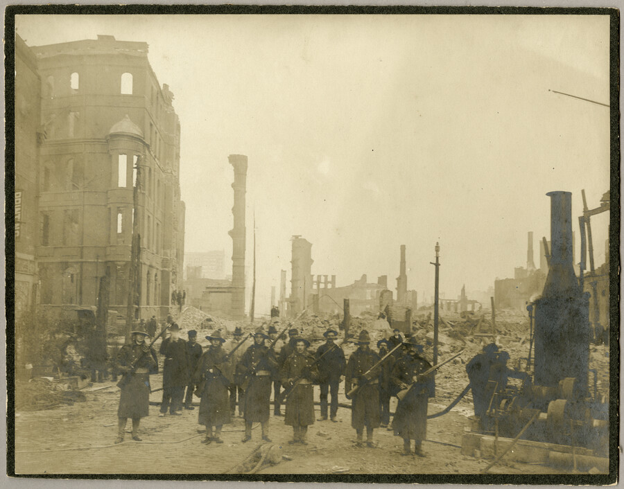 The Maryland National Guard standing before wreckage of the Great Baltimore Fire. The National Guard was called in to assist Baltimore in maintaining order and to protect the city during the catastrophe.