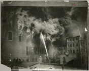 View of firefighters on a rooftop fighting the burning of an unidentified building during the Great Baltimore Fire of 1904.