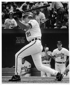 Photograph of Baltimore Orioles first baseman David Segui at bat during a home game in Baltimore, Maryland. Outfielder Jack Voigt and batting coach Jerry Narron are visible in the dugout behind Segui.