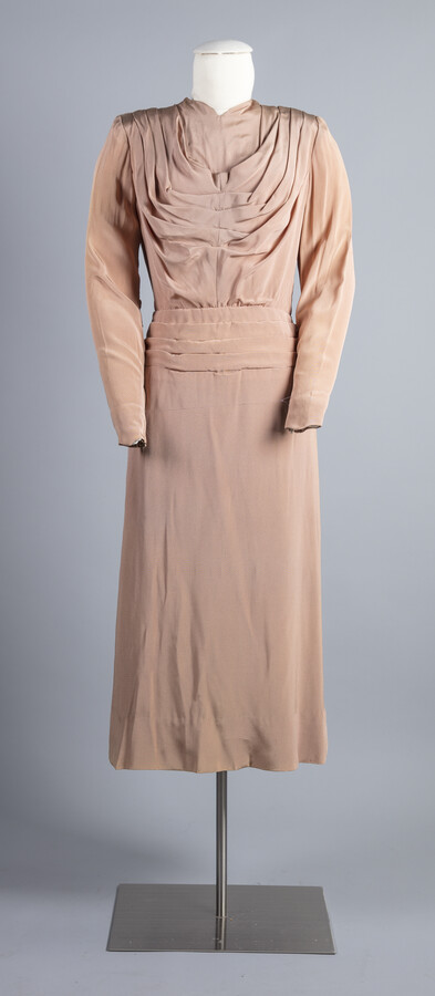Beige pleated silk crepe dress with lavender peekaboo tails.