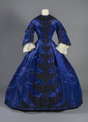 Margaretta Howard Ridgely likely purchased this royal blue, silk moiré visiting dress during her travels through England and France in 1870. Black soutache cording embellishes the dress which closes in the front with metal hooks and eyes and black thread-covered wooden buttons. Ridgely's husband, Charles Ridgely (1838–1872), did not survive the trip and passed away…
