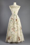 Cream silk organza gown embroidered with monkeys playing instruments, worn by Wallis Simpson (1896-1986), the Duchess of Windsor. The gown was part of Givenchy's Haute-couture collection from spring/summer 1954. The whimsical design was inspired by wallpaper seen by the designer at Les Hotels de Soubise et de Rohan-Strasbourg in France.