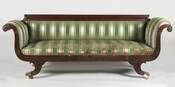 Duncan Phyfe sofa with green and gold striped fabric, wooden frame, and casters.