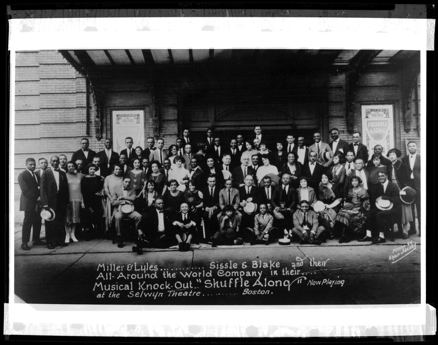 Group portrait of Flournoy Miller, Aubrey Lyles, Noble Sissle, Eubie Blake, and company. The caption beneath the group reads, "Miller and Lyles, Sissle and Blake and their All-Around the World Company in their musical knock out 'Shuffle Along' now playing at the Selwyn Theatre, Boston."