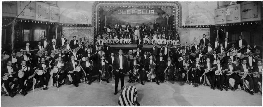 Group portrait of bandleader James Reese Europe and his Clef Club Orchestra. The first all African-American orchestra in the United States, the Clef Club Orchestra comprised about 125 members and a wide variety of instruments. The orchestra was established as musical entertainment for Europe's venue the Clef Club, which was located in the Harlem neighborhood…