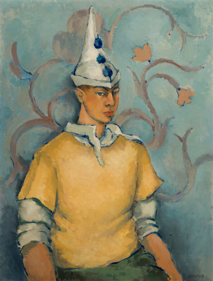 Half-length seated self portrait shows Keith Martin: the artist as harlequin wears yellow short-sleeved shirt over white long-sleeved shirt, with light green pants and pointed cap.