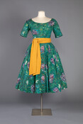 By the mid-1950s, award-winning designer Claire McCardell had made a name for herself in the world of contemporary fashion. In November 1955, Life Magazine published the article “New Fabrics Put Modern Art in Fashion,” which featured the design collaboration between artist Marc Chagall and McCardell. Chagall designed this dress’s floral cotton print and McCardell cleverly…