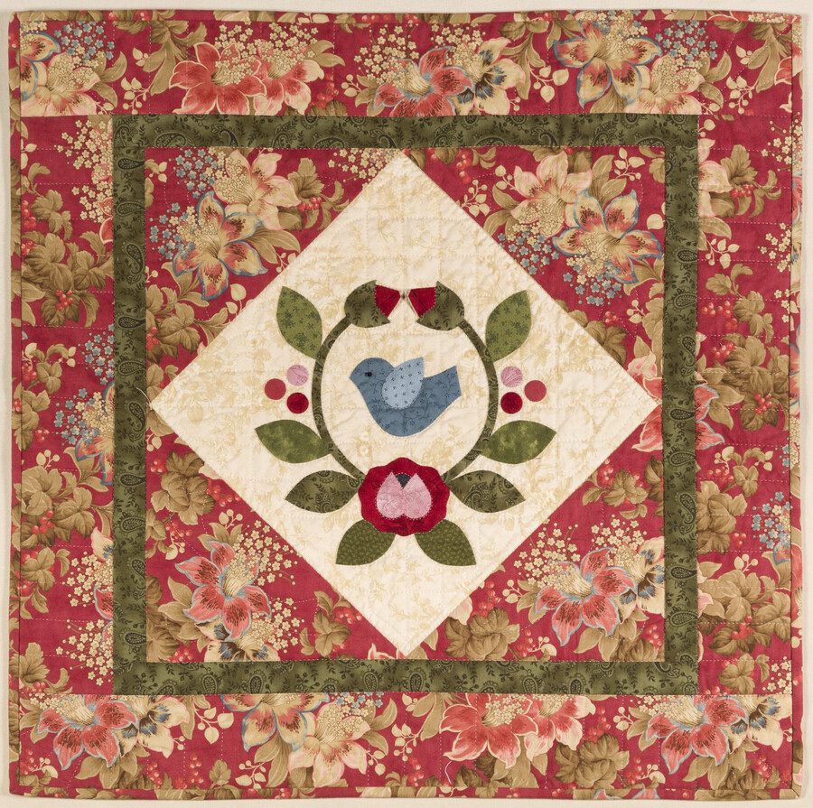 From creator Mimi Dietrich: “This block has all the elements of appliqué to get students started on a Baltimore Album Quilt. If you can stitch stems, leaves, flowers, circles, and dimensional buds, you can apply these techniques to other designs and begin to stitch a larger quilt. I love to teach this block and let…
