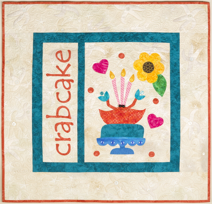 Crab Cake quilt depicting a crab on a cake stand with candles surrounded by hearts, dots, and a flower. From creator Mimi Dietrich: "When I made the ‘Hon Quilt,’ students were given a list of words that had multiple meaning. In Baltimore, we all know that a crab cake makes a great sandwich for lunch.…
