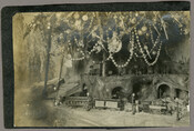 A mounted photograph of a tree and toy train in a Christmas garden.