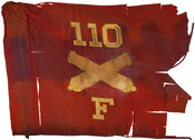 Red guidon or flag of Battery F, 110 Field Artillery Regiment, ca. 1917. It features a stitched "F", crossed cannons, and "110". The 110th Field Artillery Regiment, Maryland National Guard, was originally established as a Light Artillery Battery in Baltimore, Maryland on December 29, 1915. They expanded in spring 1917 following U.S. entry into World…