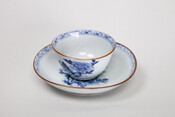 Blue and white Chinese export porcelain (b) tea cup and (a) saucer, c. 1662-1722, made during the reign of Kangxi Emperor (1654-1722), fourth Emperor of the Qing Dynasty in China.