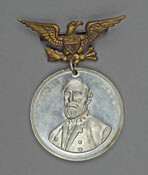 Metal medallion featuring Confederate General Robert E. Lee (1807-1870) hung from a brass eagle pin. On October 27, 1887, the city of Richmond, Virginia held a ceremony for a laying of the first stone for a monument to Lee. Pieces of the statue were built in several places before completion and the unveiling in 1890.…