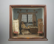 Diorama of a miniature bedroom scene with four poster bed, dresser, wardrobe, two side chairs, and a nun (doll) at center having tea and sitting at a table. The square display box is enclosed with glass window front.