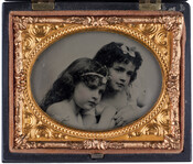 Ambrotype portrait of Anna Marie Cohen (1863-1891) (right) and an unidentified girl (left). Both are wearing dresses and have bows in their hair.
