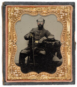 A cased ambrotype portrait of Edward Rutland Dorsey, a Confederate Lieutenant Colonel in the American Civil War. Dorsey wears his uniform with sword in hand, and his hat on a table beside him. His cheeks have been hand-colored a reddish-pink.