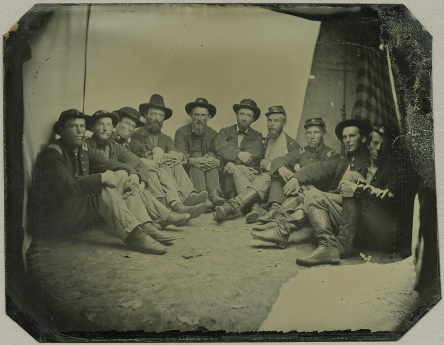Portrait of Colonel B. L. Simpson, at left, and nine other officers of the 9th Regiment Maryland Volunteer Infantry. The men wear their uniforms and sit in a semi-circle on the ground.