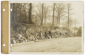 A view of men sitting on a retaining wall that was being constructed east of Greenway during the Roland Park Company's development of the Guilford neighborhood in Baltimore, Maryland. The photograph was taken from the west side of Greenway looking southeast.