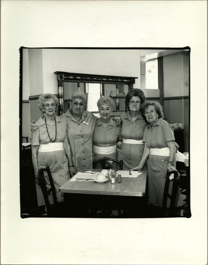 Group portrait of servers at Baltimore, Maryland's Women's Industrial Exchange, a nonprofit organization founded in 1880 providing local people with opportunities to earn money by selling handmade items to the public. The Women's Industrial Exchange ran a shop and a Tea Room while also providing instruction in cooking and needlework.
