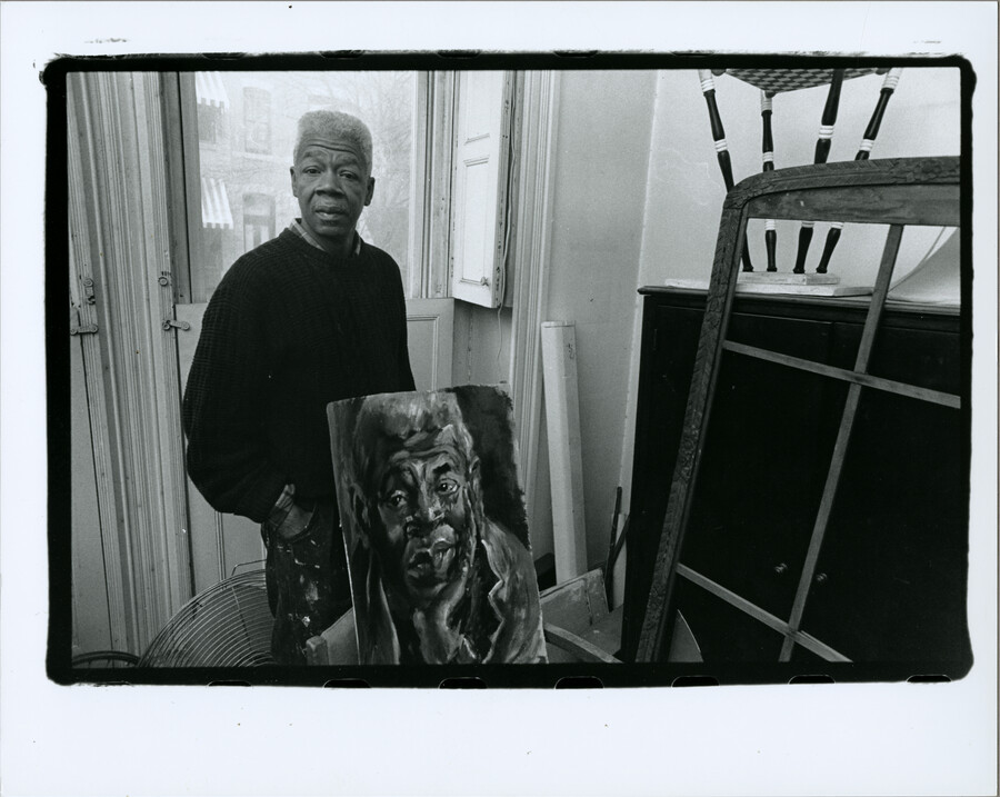 Baltimore, Maryland, artist Tom Miller posing with a self-portrait.
