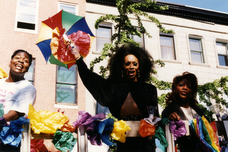 Three participants with paper flowers at the Baltimore Pride parade in Maryland. The first Baltimore Pride was held in 1975 and consisted of activists coming together in a peaceful demonstration. Throughout the decades, the Pride celebration has taken place throughout much of the city, primarily in the Mt. Vernon neighborhood and Druid Hill Park.