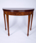 Neo-classical veneered card table with tapered legs ending in spade feet, detailed inlay including tassels and shells in medallions at tops of legs.