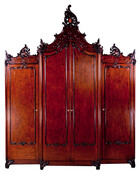 Mahogany wing wardrobe with double door at center with another door on either side. Very tall, pierced carved leaves and a coat of arms crest rail. Center door protrudes, leaf scrolled feet on castors. Likely belonged to Jérôme Napoléon Bonaparte (1805-1870).