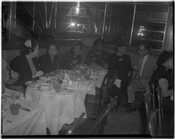 Group of unidentified people (possibly Loyal Randolph second from right) seated in a booth while dining at a restaurant or club.