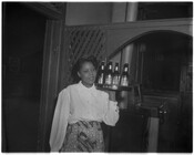 An unidentified woman (waitress) holds a tray filled with Arrow Beer inside a restaurant or club.