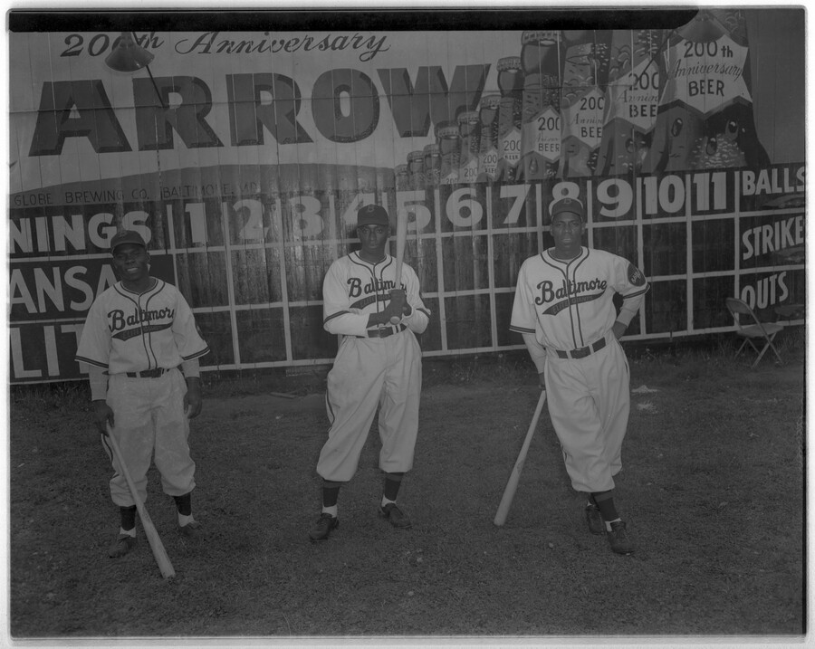 Three players of the Baltimore Elite Giants, a Negro League baseball team. From left to right: Henry Kimbo, outfielder Robert "Butch" Davis, and Lester Locket, each holding a bat. Kimbo served as the leadoff hitter for the Baltimore Elite Giants for 13 of his 18 seasons in the Negro Leagues. Locket played from 1937 to…