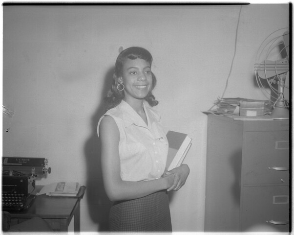 Smiling woman with book — circa 1951