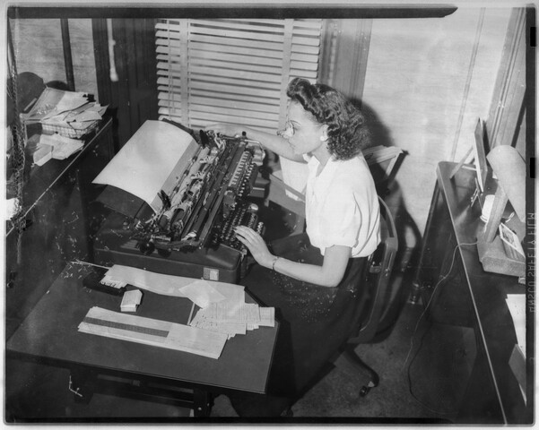 Woman seated at typewriter — circa 1948