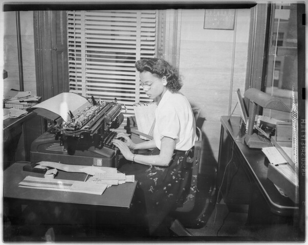 Woman typing on typewriter — circa 1948