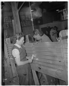 Two unidentified women working in a factory, possibly as World War II defense workers.