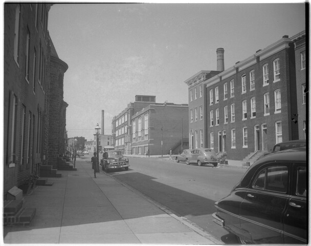 View of row houses, people, and automobiles — 1953-10