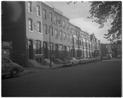 View of an unidentified block of row homes and parked cars in Baltimore, Maryland.