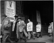 Group of people in a picket line, holding NAACP Baltimore Branch protest signs, as they march against the Jim Crow admission policy at Ford's Theatre. Protestors include Paul Robeson, third from left, and Dr. John E. T. Camper, fifth from left. By 1952, Ford's Theatre (once located at 320 West Fayette Street in Baltimore, Maryland)…