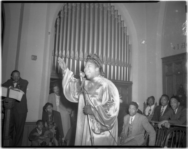 Mahalia Jackson performing with right arm raised at a church — circa 1949-02