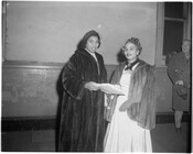 Marian Anderson (1897-1993), on left, standing beside Emma Bright. Both women are wearing fur coats and smiling at the camera.