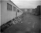 View of garbage piled up alongside Lafayette Market at 1700 Pennsylvania Avenue in Baltimore, Maryland, with the Hendin's store visible in the background. The market was built in 1871, burned down in 1953, then was rebuilt and continued operating until 1994. It reopened in 1996 as the Avenue Market.