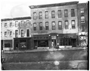 Street view of businesses on 1430-1436 Pennsylvania Avenue in Baltimore, Maryland. From left to right is Charlie Hom Laundry; West Baltimore District Office Supreme Liberty Life Insurance Company of Chicago, Illinois; a sign for "Juke Box Hop Dancing;" J. Arnell Frisby Real State Insurance Accounting and Auditing; and Pennsylvania Liqours.