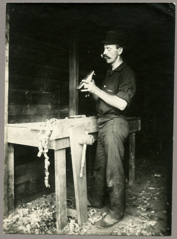 Portrait of Charles Hayden standing at workbench — circa 1895