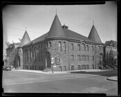 A view of the Ames Memorial United Methodist Church located at 617 Baker Street and North Carey Street, Baltimore, Maryland. The Romanesque Revival church was constructed circa 1885-1890 as a mission. The church has a rough ashlar stone facade and corner turrets with conical roofs rising over the entrances.