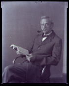Undated portrait of Charles S. Hayden, husband of Baltimore, Maryland, photographer Emily Spencer Hayden. He is seated, smoking a pipe, and holding an open book.