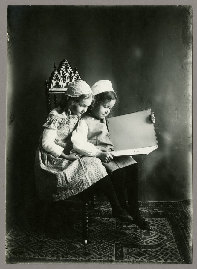 Portrait of Baltimore, Maryland, photographer Emily Spencer Hayden's daughter Ruth sitting and reading a book with a friend. Verso transcription: Ruth Hayden & Friend